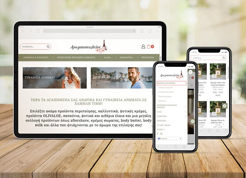 The Aromatopoleion eshop on a tablet and a phone on a wooden table