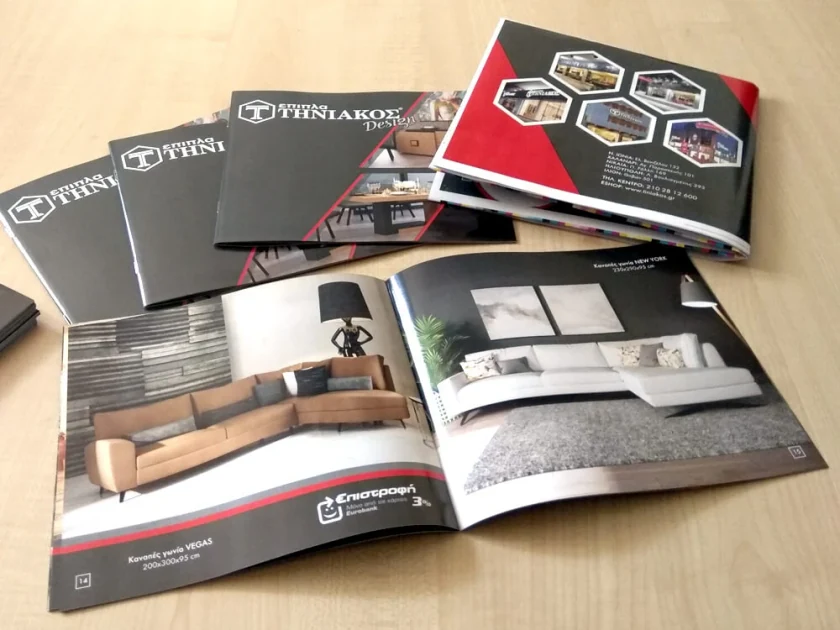 Printed copies of the Tiniakos Design brochure on a table, one open at a page of sofas